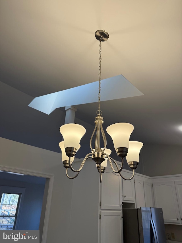 room details with a notable chandelier and stainless steel refrigerator