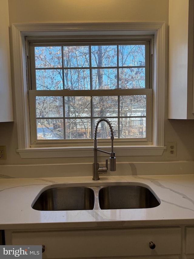 interior details featuring sink and light stone counters