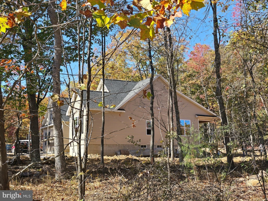 view of side of property featuring a shingled roof