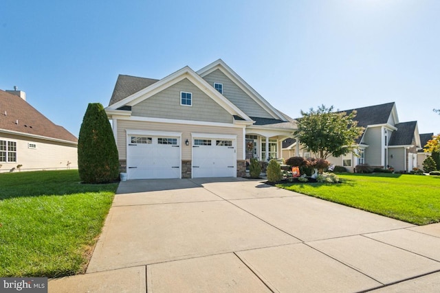 craftsman inspired home with a garage and a front lawn