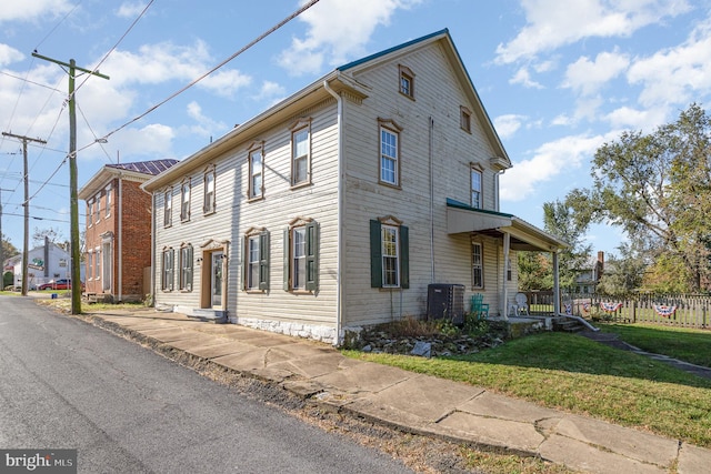 view of side of property with a yard and cooling unit