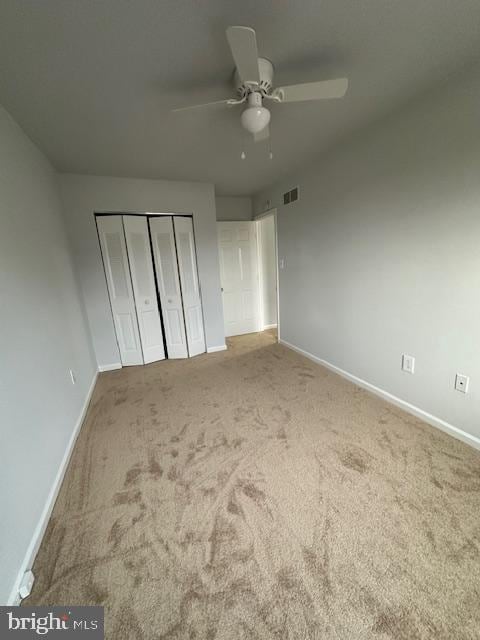 unfurnished bedroom with carpet flooring, a closet, and ceiling fan