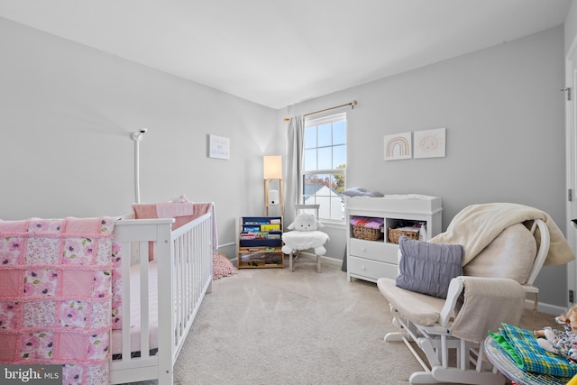 carpeted bedroom featuring a crib