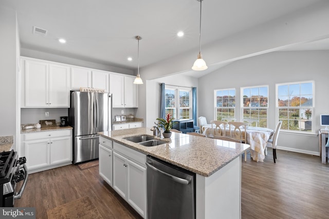 kitchen with a center island with sink, lofted ceiling, and stainless steel appliances