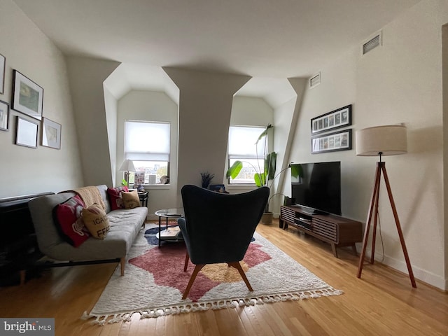 living room with light wood-type flooring and vaulted ceiling