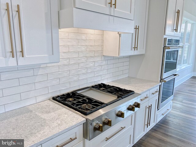 76 Long Ln, Kirkwood, PA 17536 - kitchen with decorative backsplash, stainless steel appliances, light countertops, dark wood finished floors, and white cabinetry