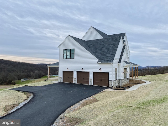 76 Long Ln, Kirkwood, PA 17536 - view of side of property with aphalt driveway, a yard, an attached garage, stone siding, and roof with shingles
