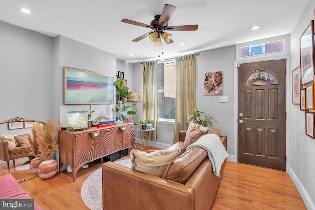 living room with light wood-type flooring and ceiling fan