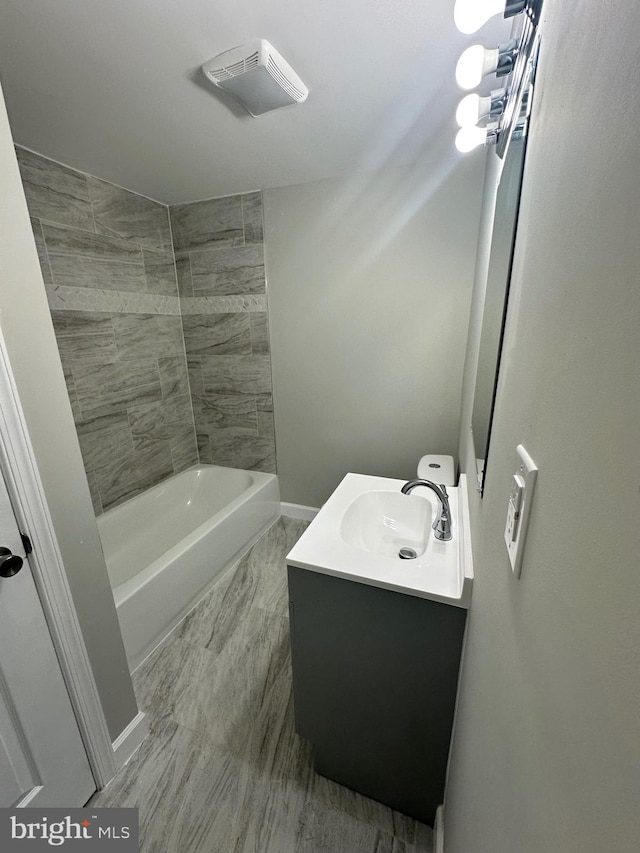 bathroom featuring vanity and tiled shower / bath