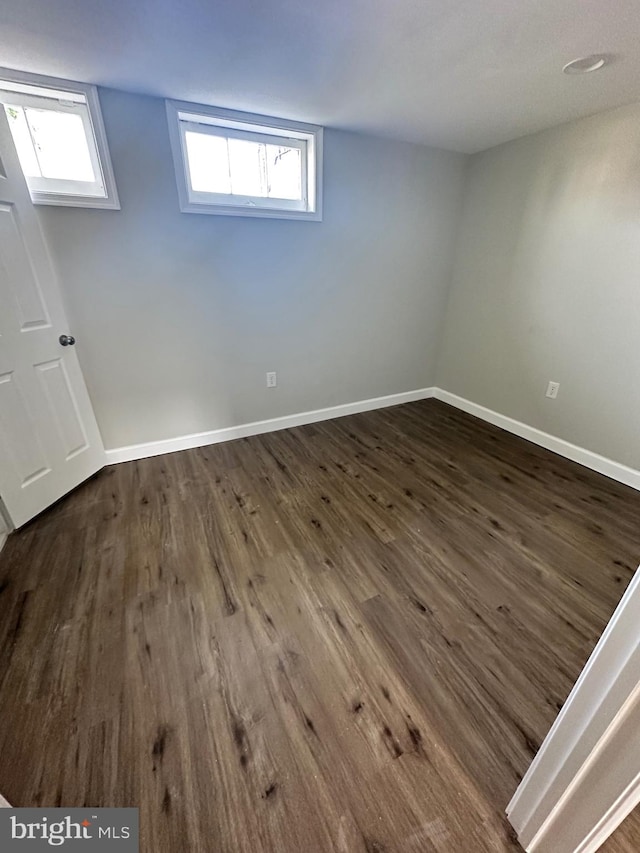 basement with dark wood-type flooring and a wealth of natural light