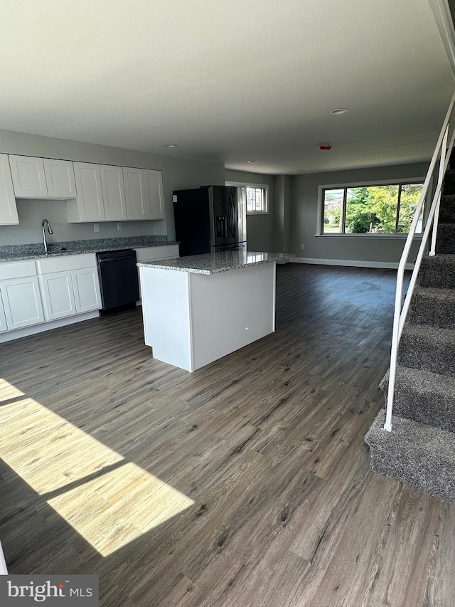 kitchen with black dishwasher, a kitchen island, dark hardwood / wood-style flooring, white cabinetry, and stainless steel refrigerator with ice dispenser