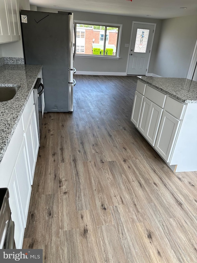 kitchen featuring light hardwood / wood-style flooring, white cabinets, and light stone countertops