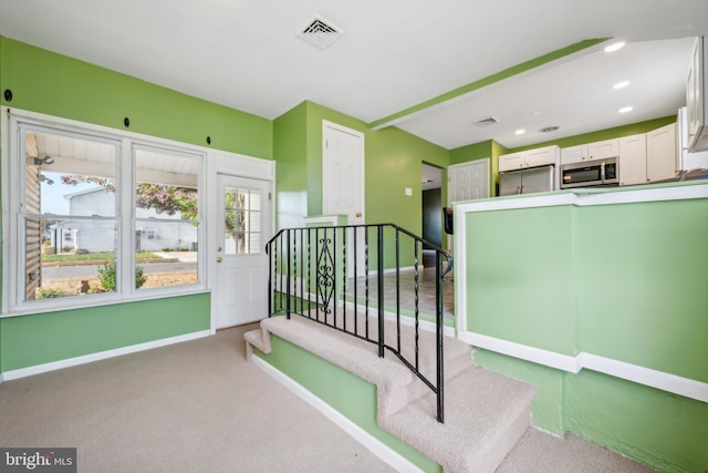 interior space featuring stainless steel refrigerator and light carpet