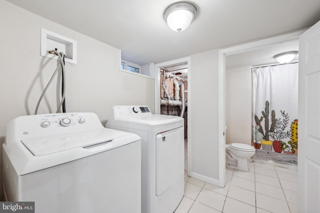 clothes washing area featuring separate washer and dryer and light tile patterned floors