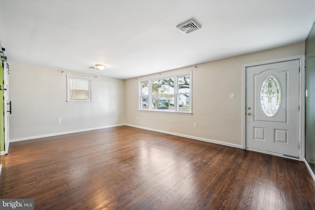 entryway featuring dark hardwood / wood-style flooring and a barn door