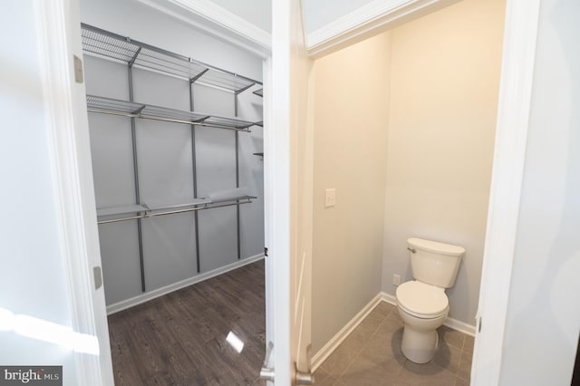 bathroom with hardwood / wood-style floors, toilet, and ornamental molding