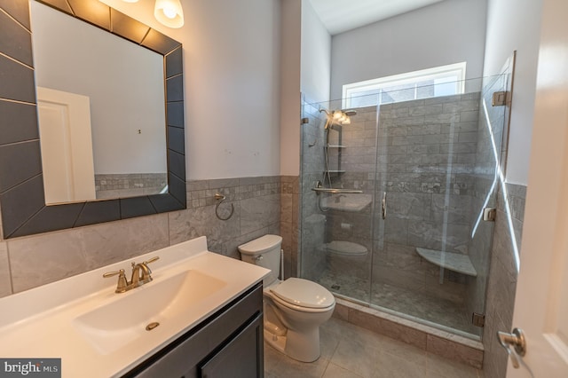 bathroom with tile patterned flooring, vanity, an enclosed shower, toilet, and tile walls