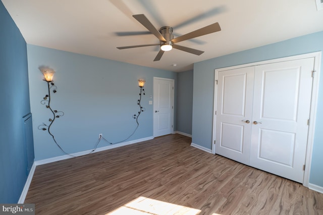 unfurnished bedroom featuring a closet, wood-type flooring, and ceiling fan