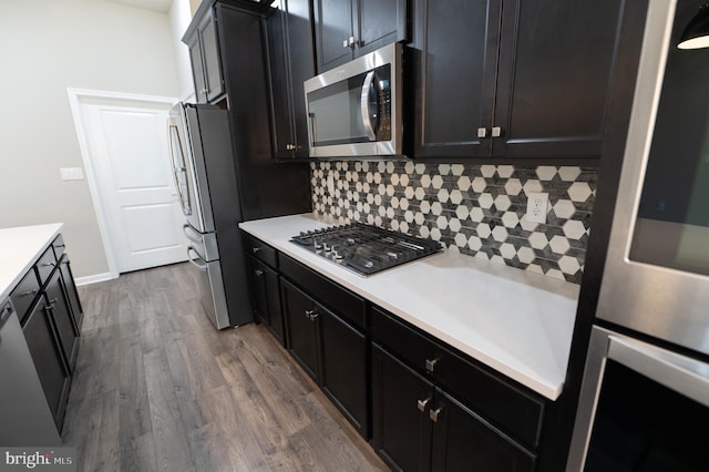 kitchen with stainless steel appliances, dark hardwood / wood-style floors, and backsplash