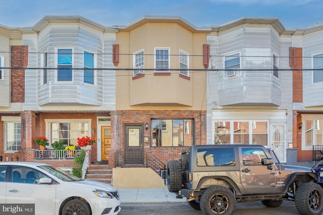 townhome / multi-family property with brick siding and stucco siding