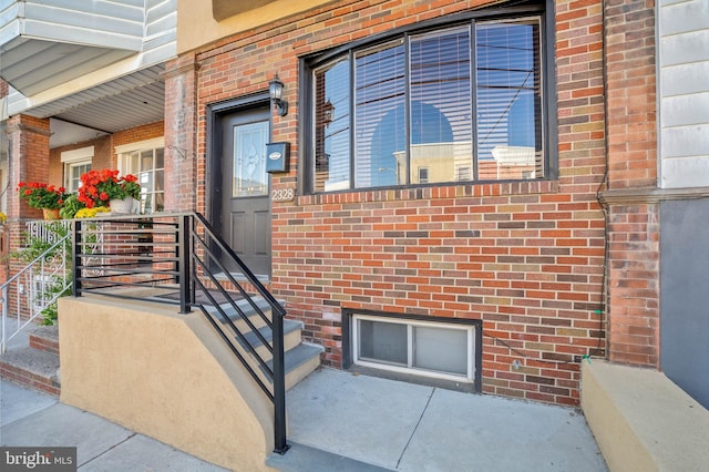 view of exterior entry featuring brick siding
