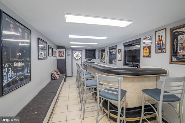 bar featuring a dry bar and light tile patterned floors
