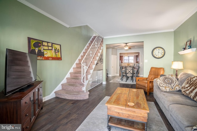 living area featuring ornamental molding, baseboards, wood finished floors, and stairway