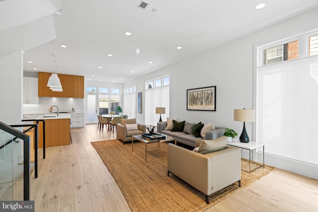 living room featuring light wood-type flooring and sink