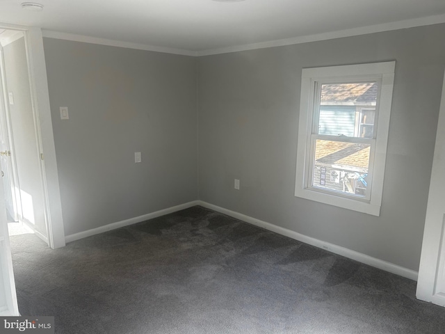 spare room with dark carpet and ornamental molding