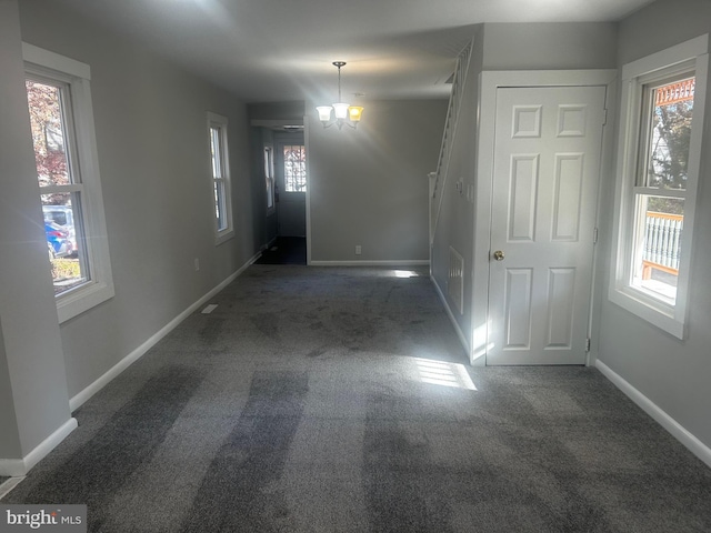 interior space with a wealth of natural light and dark carpet