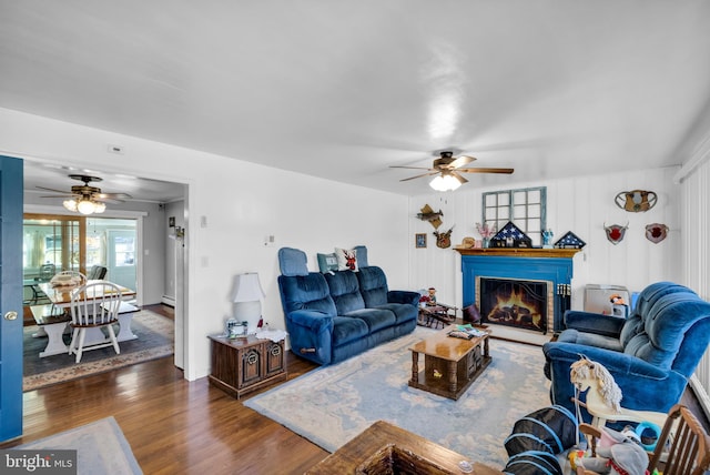 living room featuring ceiling fan and dark hardwood / wood-style flooring