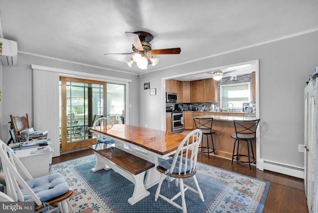 dining room with dark wood-type flooring, ornamental molding, and baseboard heating