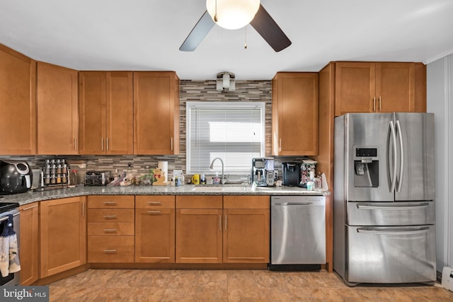 kitchen with appliances with stainless steel finishes, tasteful backsplash, sink, and stone countertops