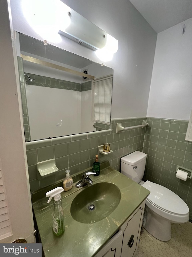 bathroom featuring vanity, toilet, tile walls, and tile patterned flooring