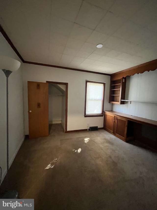 unfurnished living room featuring carpet and crown molding