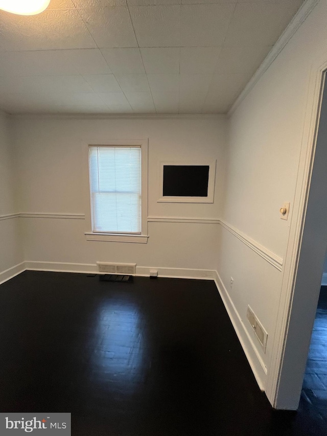 spare room with hardwood / wood-style floors and crown molding