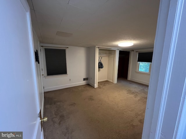 unfurnished bedroom featuring carpet floors, a textured ceiling, and a closet