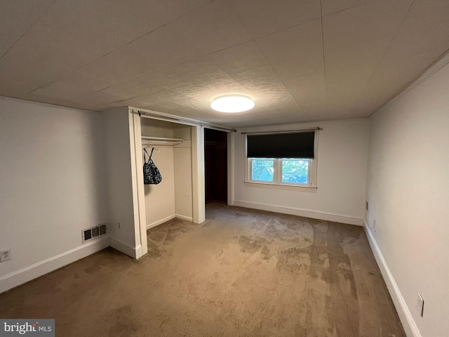 unfurnished bedroom featuring carpet and a closet