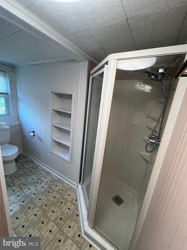 bathroom featuring toilet, walk in shower, and ornamental molding