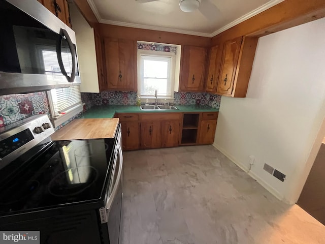 kitchen featuring ceiling fan, backsplash, sink, crown molding, and stainless steel appliances