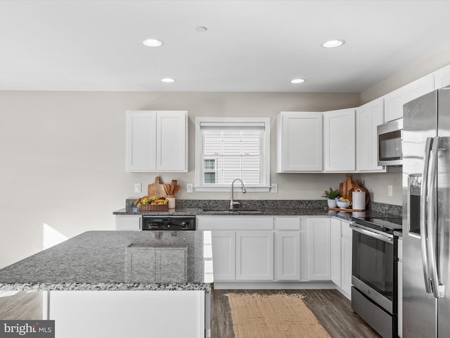 kitchen with white cabinets, stainless steel appliances, and dark wood-type flooring