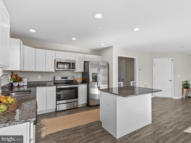 kitchen with a kitchen island, dark hardwood / wood-style floors, sink, white cabinetry, and appliances with stainless steel finishes