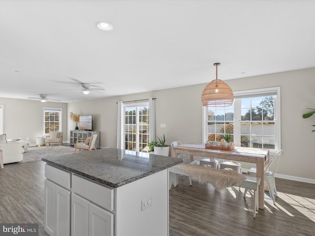 kitchen featuring white cabinetry, decorative light fixtures, dark wood-type flooring, and a wealth of natural light