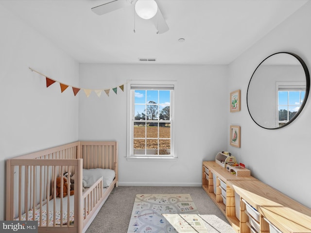 unfurnished bedroom featuring ceiling fan, carpet floors, and a nursery area