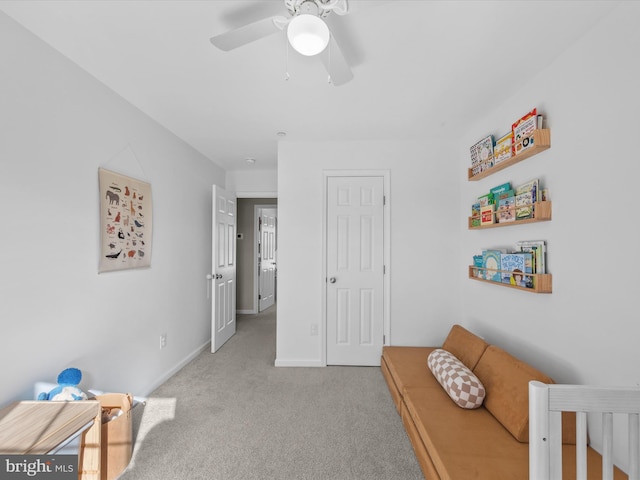 living area with light carpet and ceiling fan