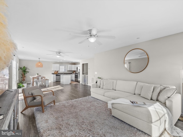 living room with dark hardwood / wood-style floors and ceiling fan