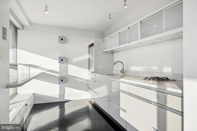 kitchen with white cabinetry, sink, and stainless steel gas stovetop