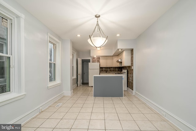 kitchen with backsplash, light tile patterned flooring, decorative light fixtures, a center island, and white refrigerator