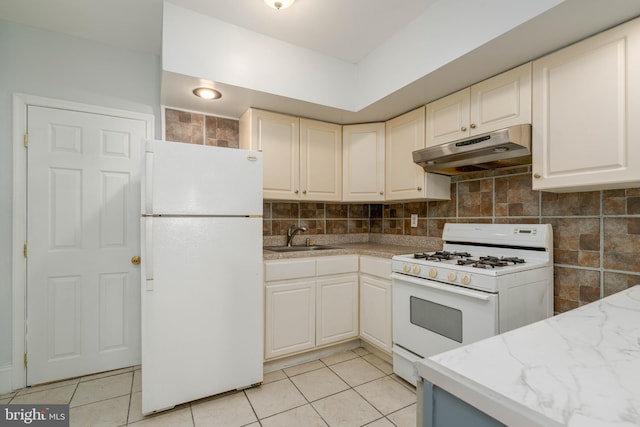 kitchen with sink, decorative backsplash, light tile patterned flooring, and white appliances