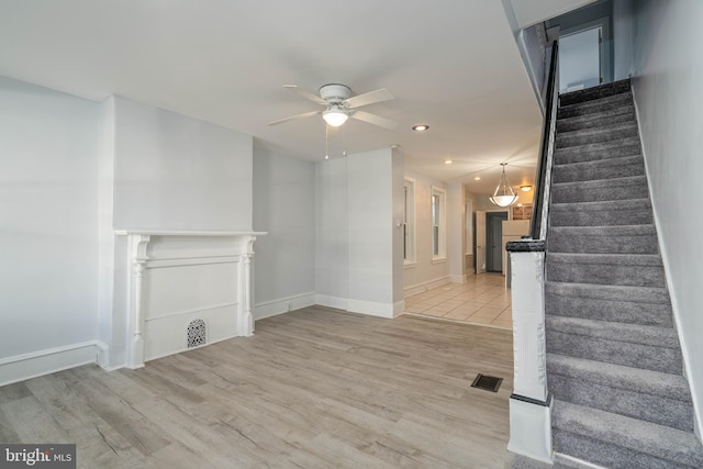 unfurnished living room with light hardwood / wood-style flooring and ceiling fan